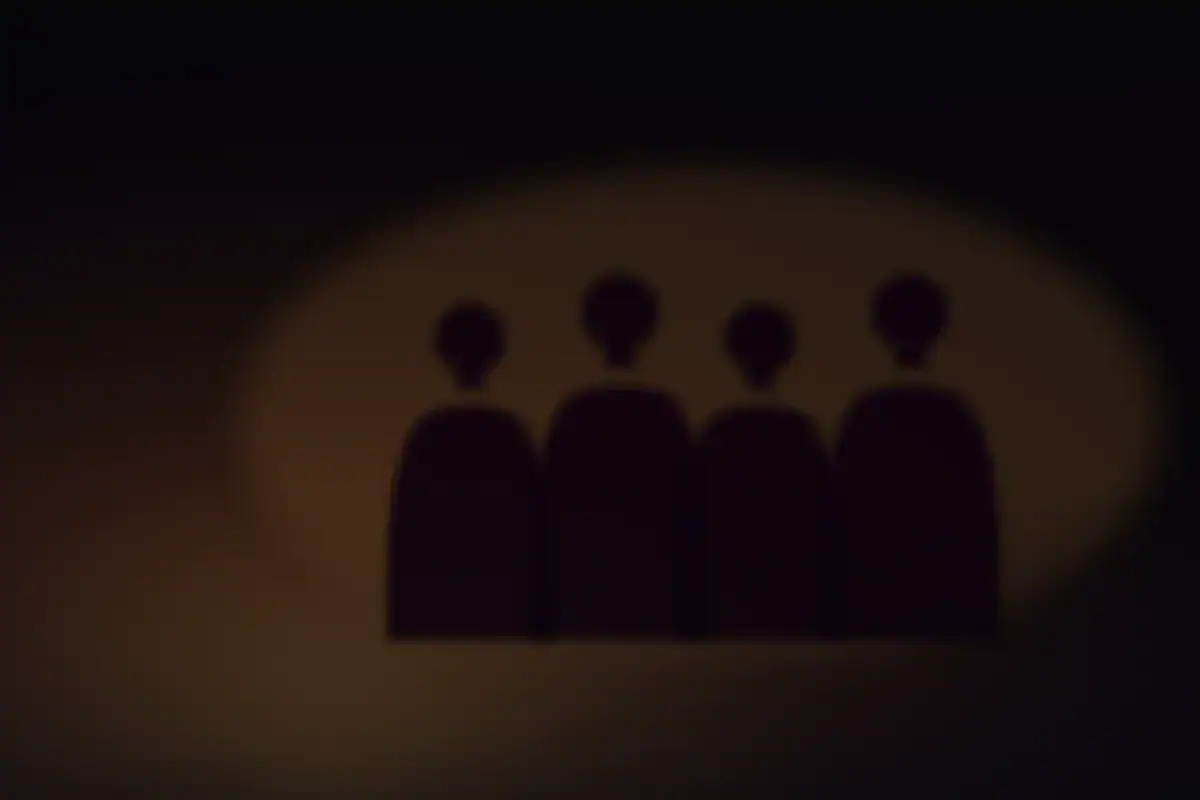 Shadows of figures cast on a cave wall by firelight
